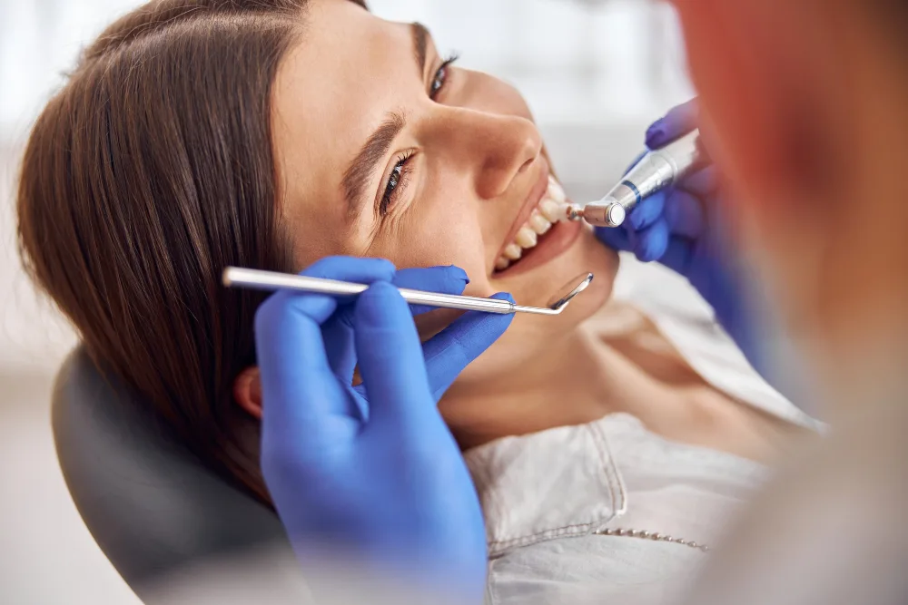 Paziente sorridente durante una seduta di igiene dentale professionale